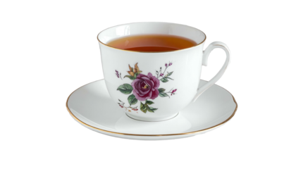 Floral teacup with tea, on a saucer, against a black backdrop