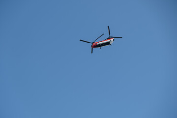 Tandem rotor helicopter flying against blue sky