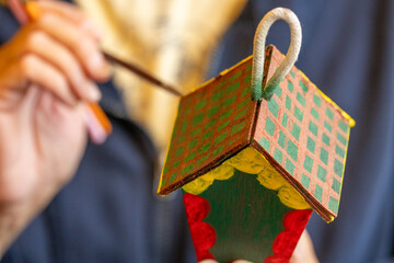 Shallow DOF image of woman painting a small birdhouse