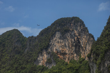 A large plane is flying over the mountains.