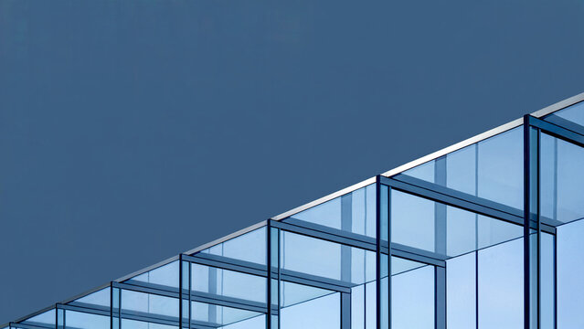 Minimalist abstract architecture view of modern glass structure against a clean blue-gray sky backdrop
