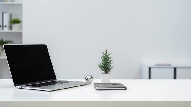 Modern desk with open laptop and small Christmas tree