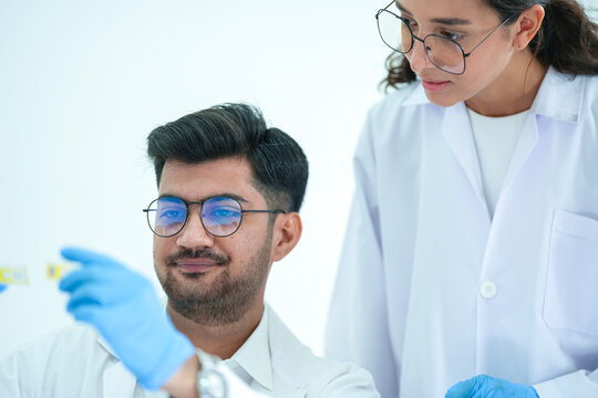 Diverse team of scientists analyzing medical research data in modern laboratory, discussing clinical test results and collaborating on biology project.
