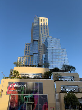 LOS ANGELES, CA, OCT 1, 2025: Tall glass and concrete tower at The Grand in DTLA, with asymmetrical stepped design dominates skyline, featuring dataland art exhibition advertisement at base level