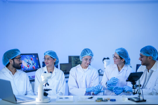 Multidisciplinary research team collaborating on genomic sequencing using AI-powered simulation and digital twin technology in smart lab. - Powered by Adobe