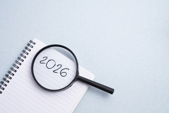 Happy New Year 2026 and a notepad on a colored background. Layout for writing annual business plans, schedules, as well as New Year's resolutions and goals. - Powered by Adobe