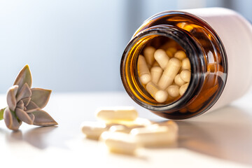 Tight macro on amber bottle mouth filled with capsules; soft focus foreground and white label suggest vitamin health, neutral packaging and flexible lifestyle advertising placements.