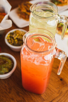 Margarita pitchers on a table with food at a Mexican restaurant