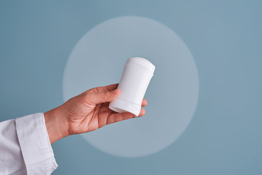 Hand holding white blank deodorant stick