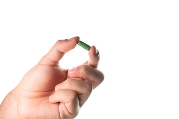 Detailed close-up of a male hand pinching a green capsule. Focus on the texture and color, suitable...