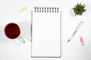 Clean office desk flat lay with a blank sketchbook, red tea cup, pen, and succulent. Perfect mockup for business branding, education, or blogging.