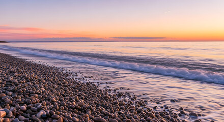 A scenic view of a pebble beach meeting the ocean under a colorful pastel sunset sky horizon line