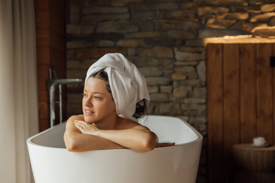 Woman relaxing in a modern bathtub in a peaceful setting