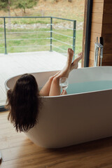 Relaxing bath experience with a glass of water in a modern tub