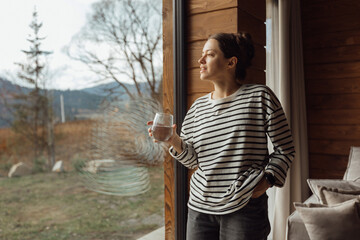 Cozy indoor scene with a woman relaxing and working on a laptop