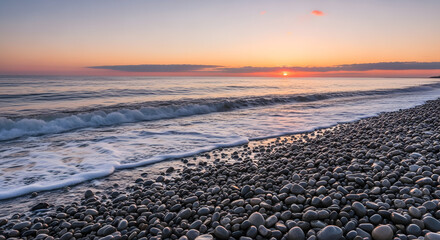 A scenic view of a rocky beach with waves crashing during a colorful sunset at the ocean shore