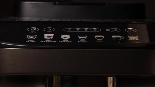 Closeup view of a modern coffee machine control panel with glowing drink selection icons and illuminated buttons for various coffee options