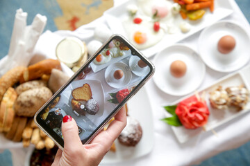 Woman using smartphone to take photos of food before eating