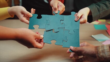 Two hands grasp colorful puzzle pieces over a desk, symbolizing teamwork and problem-solving in a creative office. Ideal for illustrating collaboration and innovation. SACTR - Powered by Adobe