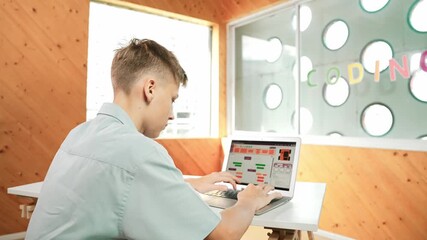 Back view of high school student working on laptop analysis data at STEM science class. Smart happy caucasian boy learning to coding engineering prompt or programming system at STEM class. Edification - Powered by Adobe