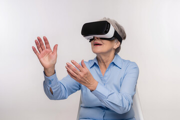 A woman enjoys a virtual reality experience while sitting indoors, demonstrating the technology to seniors. Generative AI