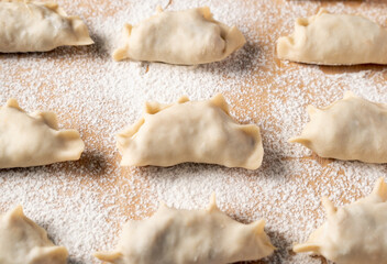 A row of dumplings are sitting on a table covered in flour