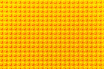 Naklejka premium Vibrant Yellow LEGO Brick Surface Texture Background