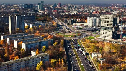 Poznan cityscape autumn traffic. Aerial panorama busy urban roundabout surrounded residential blocks, office buildings roads leading city center vibrant fall colors
