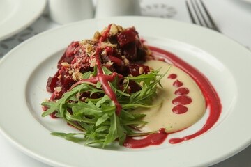 Beetroot salad served with hummus and fresh arugula	