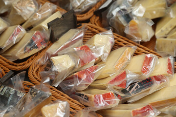 Various slices of cheese in a transparent package, pieces of cheese in an empty package on the store counter. Сoncept of long-term storage and freshness