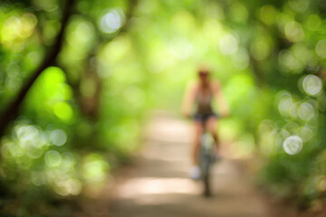 Blurred woman cycling along forest trail with vibrant green foliage, sunlight filtering through trees, peaceful outdoor activity, summer adventure, healthy lifestyle, motion, relaxation