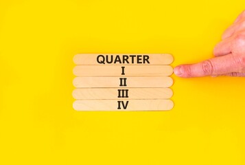 1st first quarter 1 symbol. Concept word Quarter 1 on beautiful wooden sticks. Beautiful yellow background. Businessman's hand. Business, happy 1st first quarter 1 Q1 concept. Copy space.