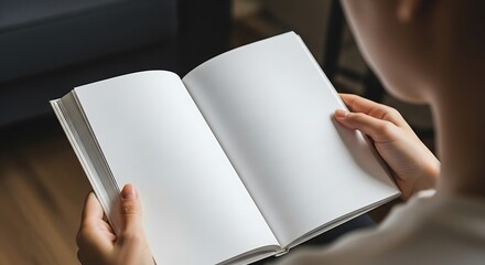 Closeup of a person holding an open book with blank white pages, ready for text or design, offering a customizable template for various content