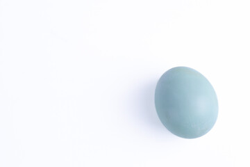 Single pastel blue-green egg on a white background with ample copy space, resembling an Indonesian salt-cured duck egg telur asin or a plain Easter egg, ideal for food, holiday
