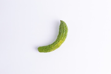 Flat lay top view single fresh green bitter melon isolated on white background. Organic herbal vegetable food concept.
