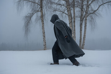 Mysterious figure walking through snowy winter landscape with birch trees, evoking suspense and solitude, perfect for book covers or dramatic storytelling concepts