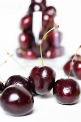 Sweet ripe cherries in  glass bowl around white background