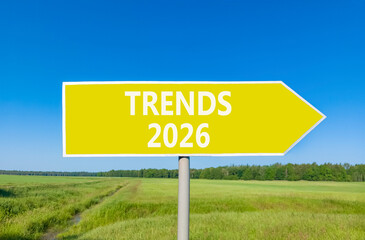 Trends 2026 new year symbol. Concept words Trends 2026 on beautiful yellow road sign. Beautiful green grass field forest and blue sky background. Business and Trends 2026 new year concept. Copy space.