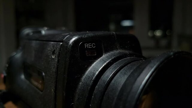 Close-up red rec light on vintage camera, atmospheric and moody.