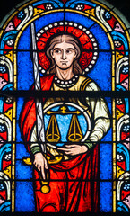 Stained glass (19th century) of symbol of the scales of Justice weighing the souls and actions of each person.