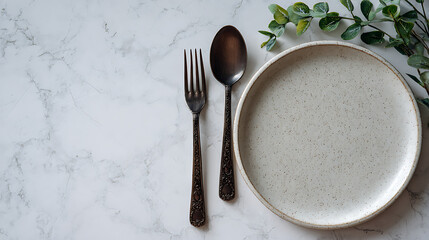 Minimalist dining setting with ornate cutlery and speckled plate top down