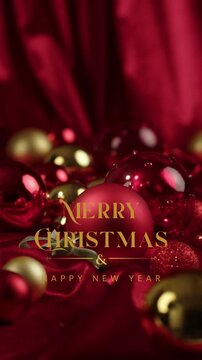 Luxurious video greeting with animated gold text reading Merry Christmas and Happy New Year on the background of red and gold christmas balls