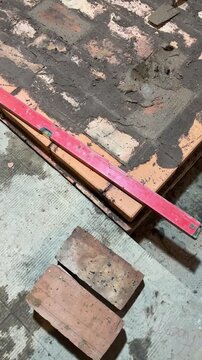 Brickwork of the heating furnace base Builders level Stove construction.