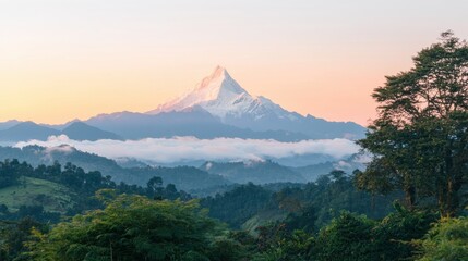 A majestic snow-capped mountain peak rises above a lush green valley, with a warm orange sky and a soft, hazy atmosphere.