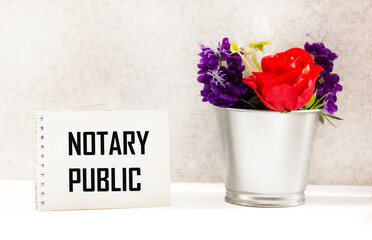 There is a notebook on the table with the inscription NOTARY PUBLIC