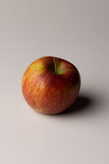 Iconic red apple on a clean white background with a soft cast shadow, highlighting its shiny surface and classic shape.