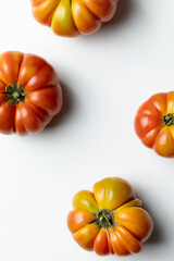 Top view of a composition of Sicilian ribbed tomatoes on a clean white background, creating a fresh and appetizing food scene ideal for culinary, organic, and Mediterranean themes.