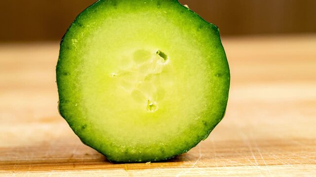 Chopping Cucumber. Closeup of Sliced Vegetable on Wooden Cutting Board. Stop Motion Animation