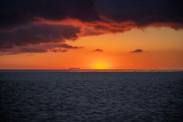 Morning Sandy Beach with Sea and Cloudy Sunrise. Beautiful Outside Scenery with Sand during Dawn.