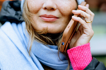 Woman talking on her phone while wearing a warm scarf